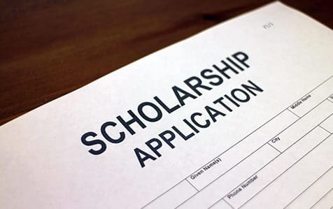 A scholarship application is shown on top of the table.